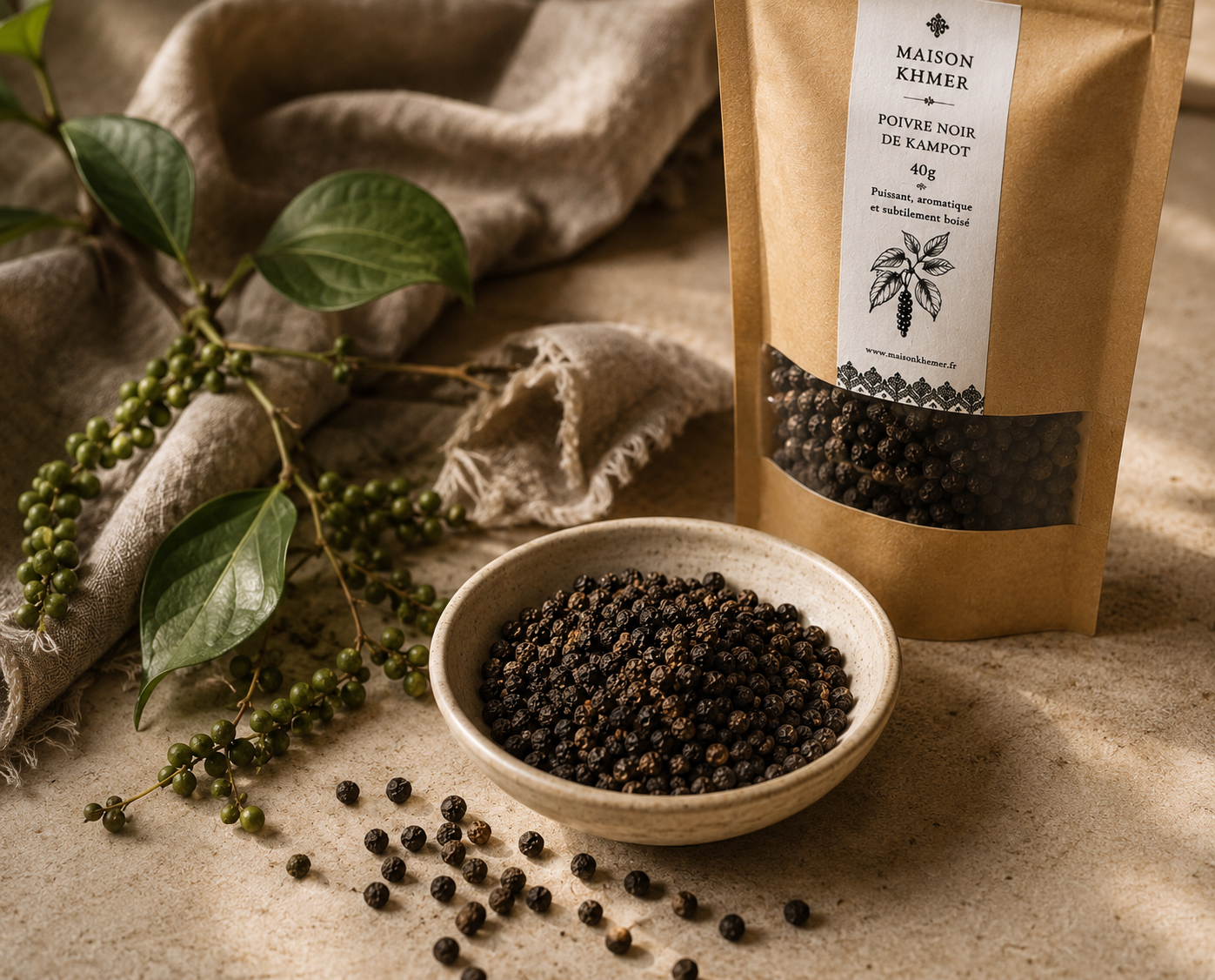 Sachet de poivre noir de Kampot et bol de grains sur toile de lin